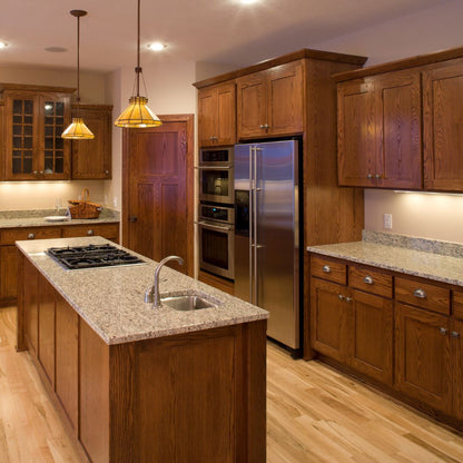 Luxury Italian-Inspired Kitchen Design
A luxurious Italian-style custom kitchen with dark wooden cabinets, integrated appliances, and a spacious kitchen pantry illuminated by warm pendant lighting.