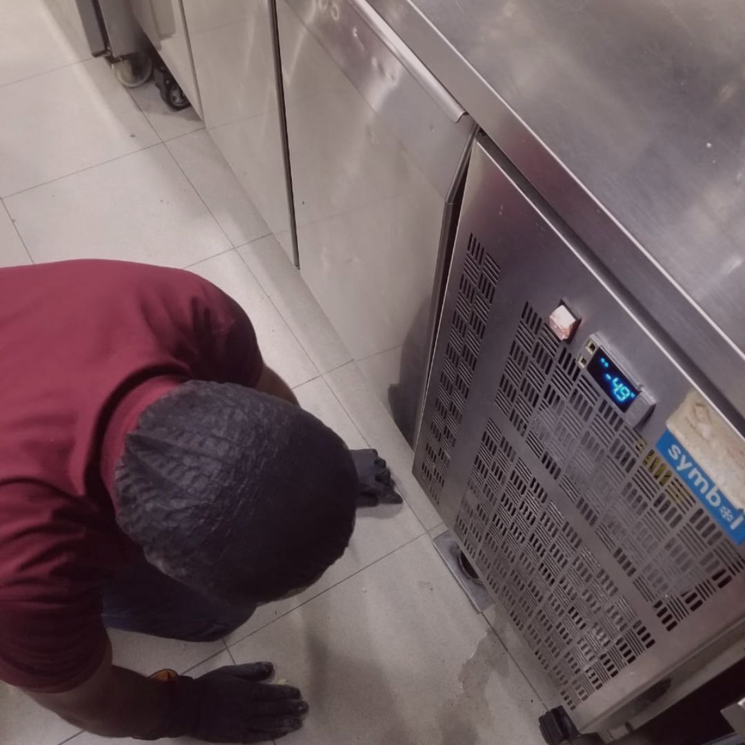 Fix It Mates technician inspecting commercial kitchen equipment to ensure proper functionality, safety, and compliance with maintenance standards for optimal performance in a busy kitchen environment.